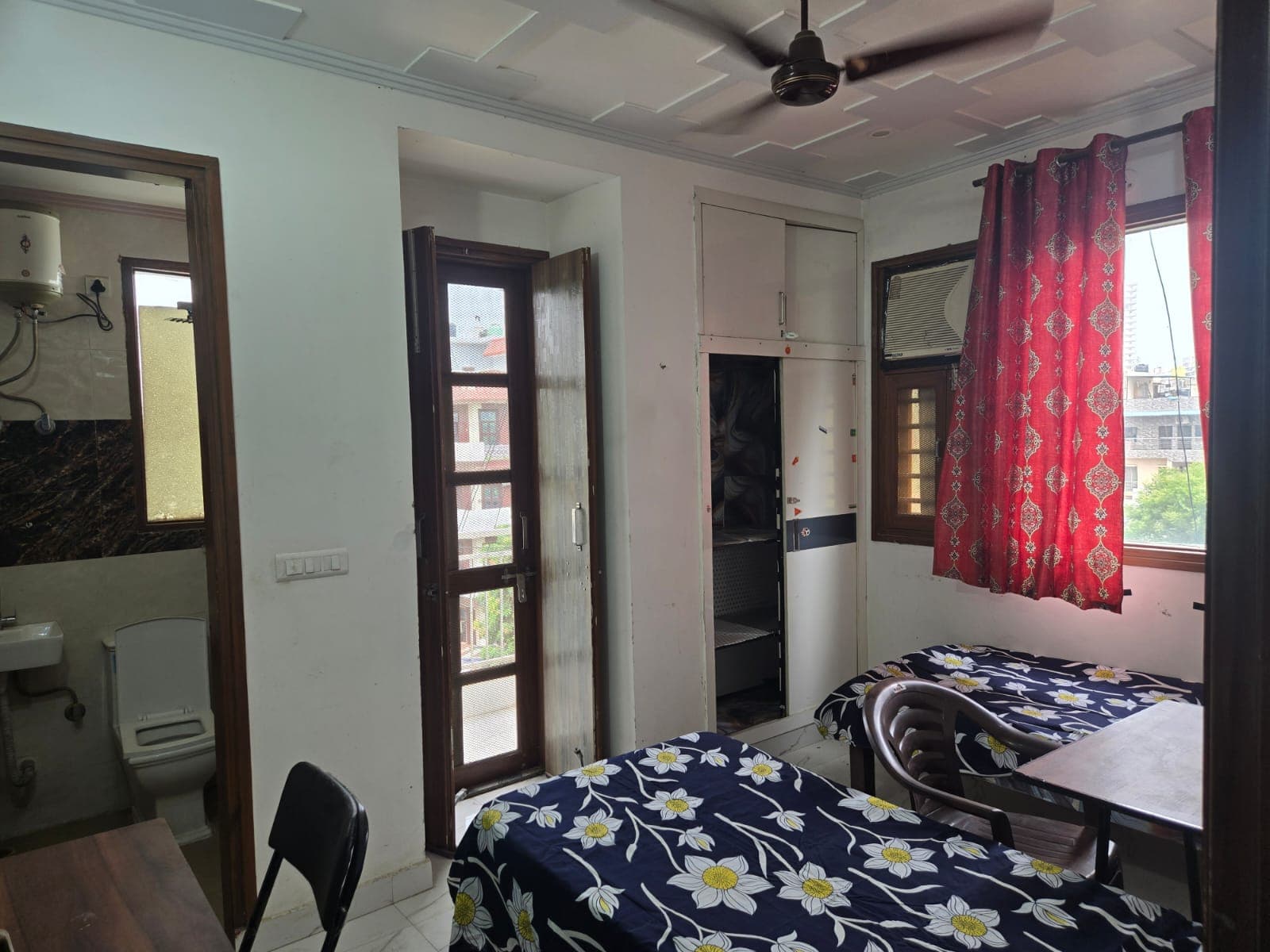 Room with an attached bathroom, balcony door and AC